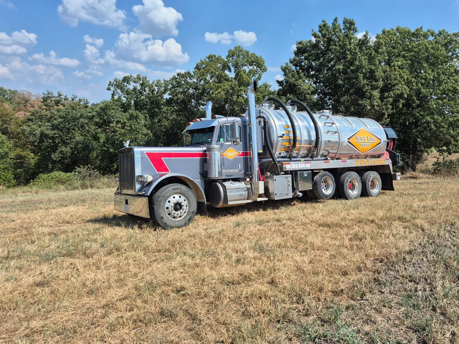 A State Line Septic pump truck on a job in an open field